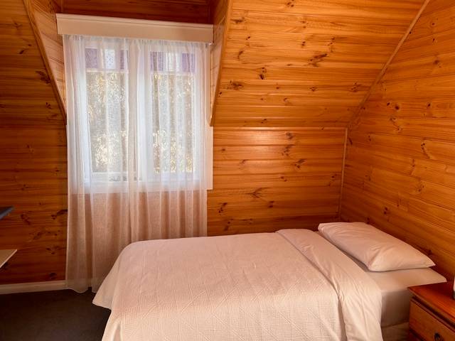 Sails villa upstairs bedroom with timber-lined walls
