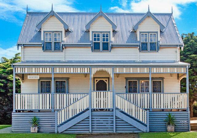 Sails Double Storey Villa: cream two-storey villa with white verandah set on lawns