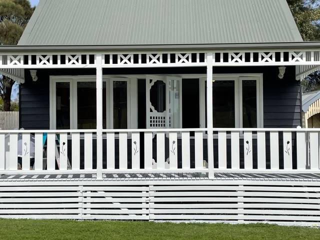 Sandpiper Classic Villa: navy weatherboard cottage with white lace verandah