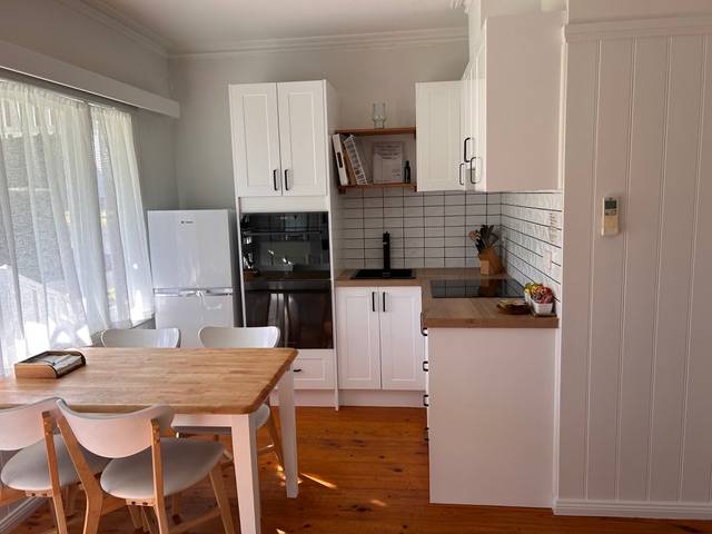 Sandpiper villa white kitchen with timber dining table