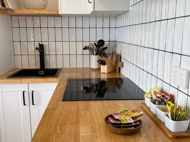 Sandpiper villa kitchen bench with black tiles and cooktop